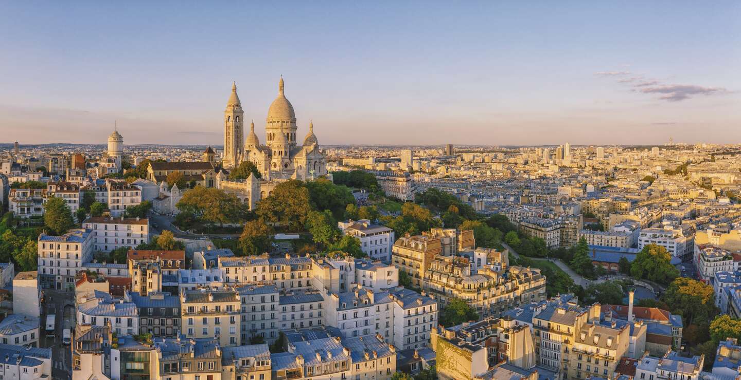 Luftaufnahme des Montmartre-Hügels mit der Basilique du Sacre-Coeur in Paris bei Sonnenuntergang | © Gettyimages.com/pawel.gaul