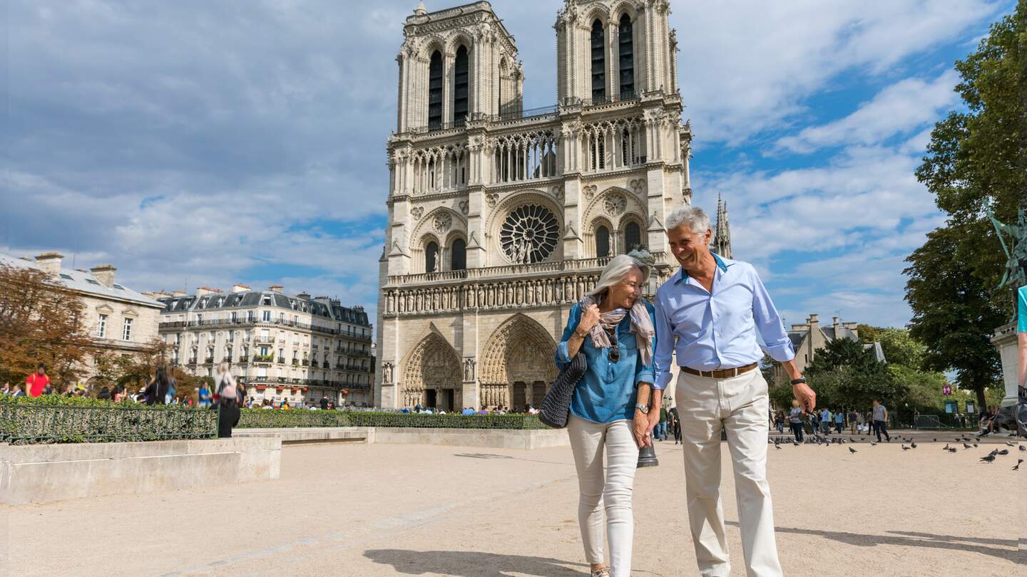 Glückliches Seniorenpaar vor der Kathedrale Notre-Dame in Paris mit einem wunderbaren Urlaub | © Gettyimages.com/LeoPatrizi