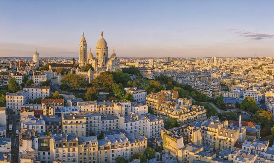Luftaufnahme des Montmartre-Hügels mit der Basilique du Sacre-Coeur in Paris bei Sonnenuntergang | © Gettyimages.com/pawel.gaul