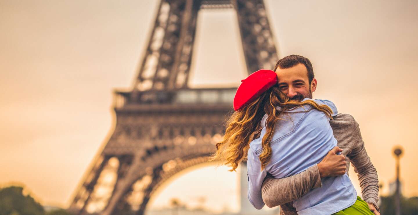 Junges Paris, die ihre Liebe vor dem Eiffelturm in Paris teilen  | © Gettyimages.com/AleksandarNakic