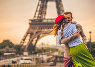 Junges Paris, die ihre Liebe vor dem Eiffelturm in Paris teilen  | © Gettyimages.com/AleksandarNakic