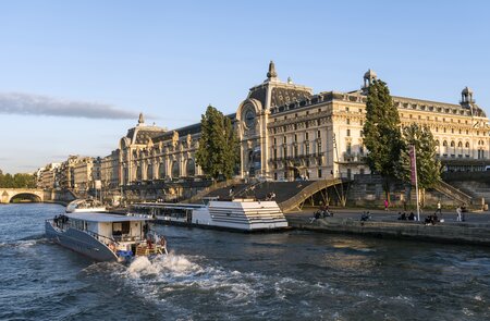 Musée d'Orsay an der Seine in Paris, ein Boot fahrend im Vordergrund auf der Seine | © Gettyimages.com/omersukrugoksu