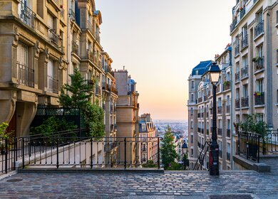 Blick auf die gemuetliche Strasse und eine Treppe im Viertel Montmartre in Paris | © Gettyimages.com/DaLiu