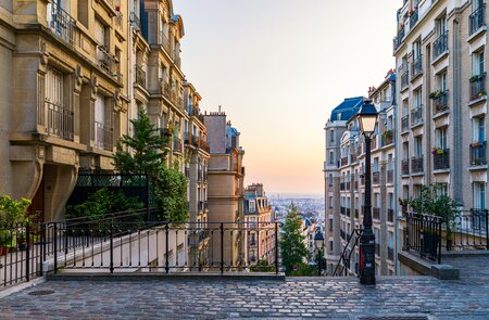 Blick auf die gemuetliche Strasse und eine Treppe im Viertel Montmartre in Paris | © Gettyimages.com/DaLiu