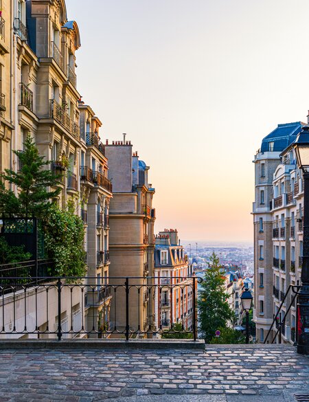 Blick auf die gemuetliche Strasse und eine Treppe im Viertel Montmartre in Paris | © Gettyimages.com/DaLiu