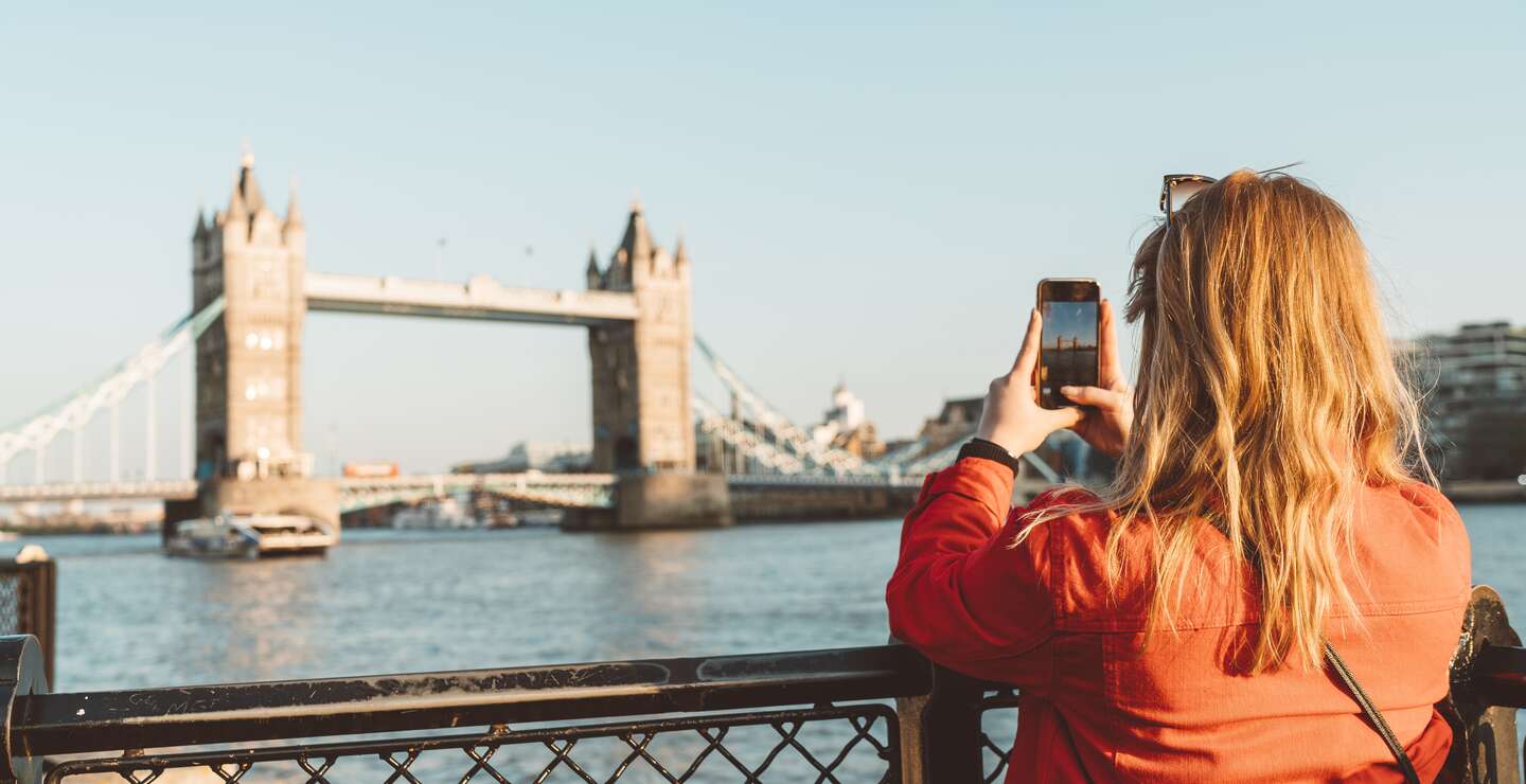 Touristin auf Städtereise erkundet die bekanntesten Sehenswürdigkeiten Londons – mit der Tower Bridge im Hintergrund. | © Gettyimages.com/Ziga Plahutar