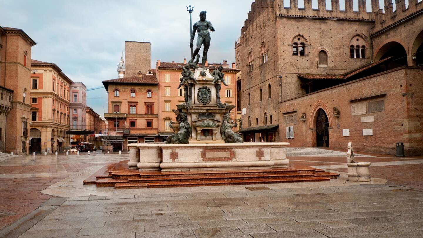 Blick auf den Neptunbrunnen auf der Piazza Maggiore in Bologna mit bewoelktem Himmel | © Gettyimages.com/treeffe