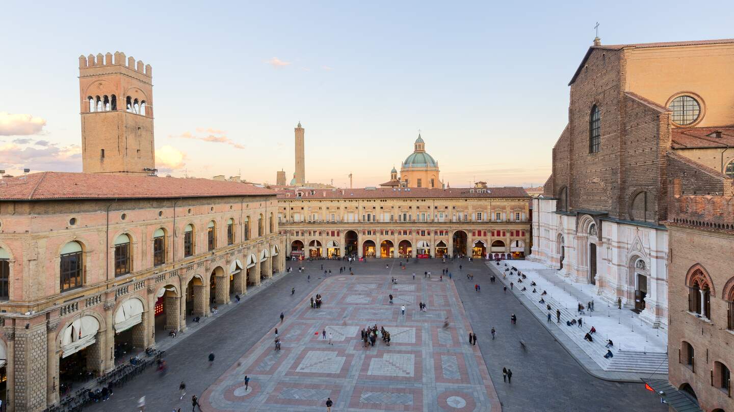 Touristen aus aller Welt für die Piazza Maggiore mit der basilika San Pietrino und der Torre dell’Arengo | © Gettyimages.com/minoandriani
