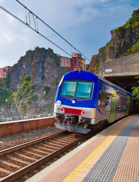 Erster Ausblick vom Bahnhof in Manarola, Cinque Terre, auf das malerische Dorf mit seinen bunten Häusern, das an der Klippe thront, mit dem Ligurischen Meer im Hintergrund. | © Gettyimages.com/Elijah-Lovkoff