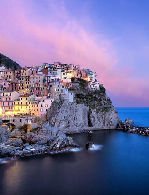Das Cinque Terre Dorf Manarola bei Abenddämmerung mit sanft erleuchteten Straßen | © Gettyimages.com/FilippoBacci