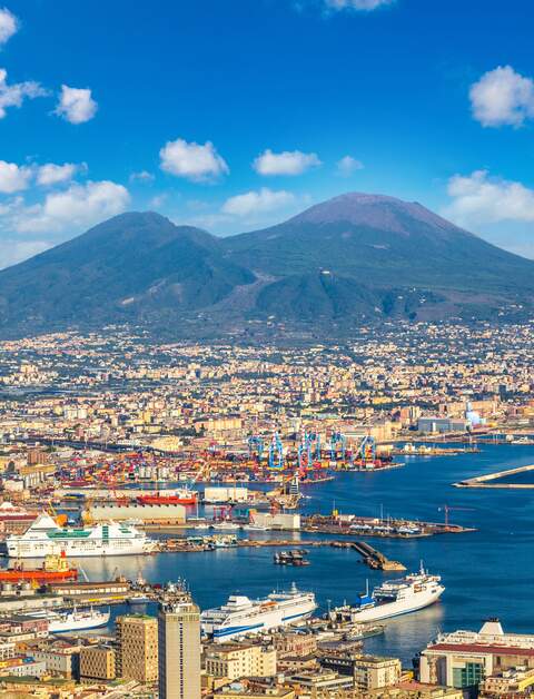 Neapel und der Vesuv im Hintergrund bei Sonnenuntergang an einem Sommertag in Italien | © Gettyimages.com/bloodua