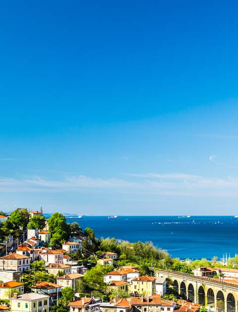 Panoramablick auf die Stadt Triest mit dem Faro della Vittoria, einer Brücke und dem Adriatischen Meer im Hintergrund | © Gettyimages.com/zakaz86