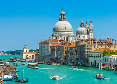 Canal Grande und Basilica di Santa Maria della Salute in Venedig | © Gettyimages.com/bluejayphoto Gondeln fahren im Wasser auf dem Canal Grande in Venedig, die Basilica di Santa Maria della Salute im Hintergrund | © Gettyimages.com/bluejayphoto