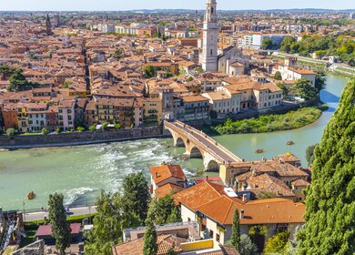 Blick auf das historische Zentrum der Stadt Verona, Italien und die Bruecke Ponte Pietra und die Etsch von der Huegelfestung Castel San Pietro, mit Gruppen von Floeßern, die eine Fahrt auf dem Fluss geniessen.  | © Gettyimages.com/kirkfisher