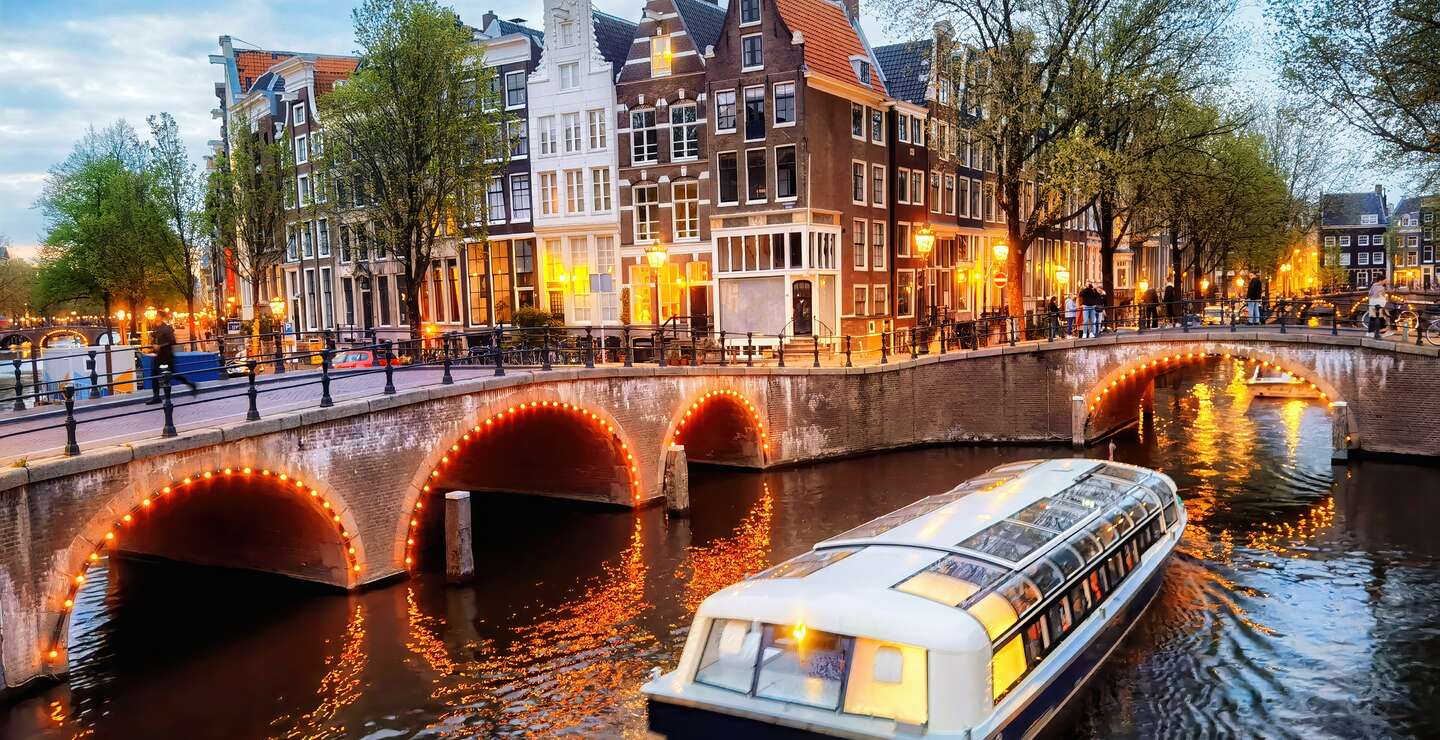 Abendliche Rundfahrt durch die beleuchteten Grachten in Amsterdam | © Gettyimages.com/Eloi_Omella