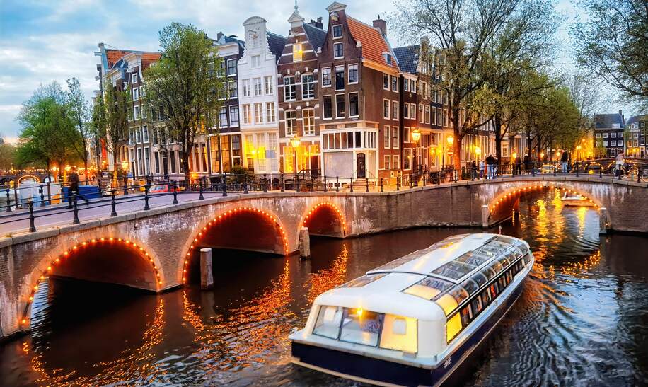 Abendliche Rundfahrt durch die beleuchteten Grachten in Amsterdam | © Gettyimages.com/Eloi_Omella