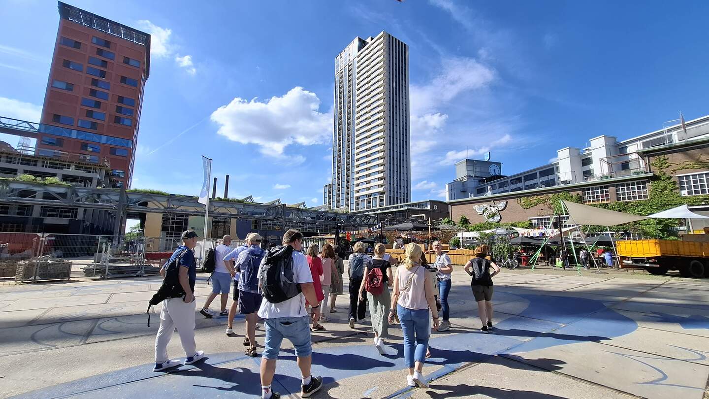 Menschen tummeln sich in der Innenstadt von Eindhoven in Brabant, in den Niederlanden. Im Hintergrund ist ein Wolkenkratzer zu sehen. | © Rolf Pepers