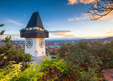 Klassischer Panoramablick auf die historische Stadt Graz mit dem beruehmten Grazer Uhrturm bei schoenem Abendlicht bei Sonnenuntergang, Steiermark, Oesterreich | © Gettyimages.com/bluejayphoto