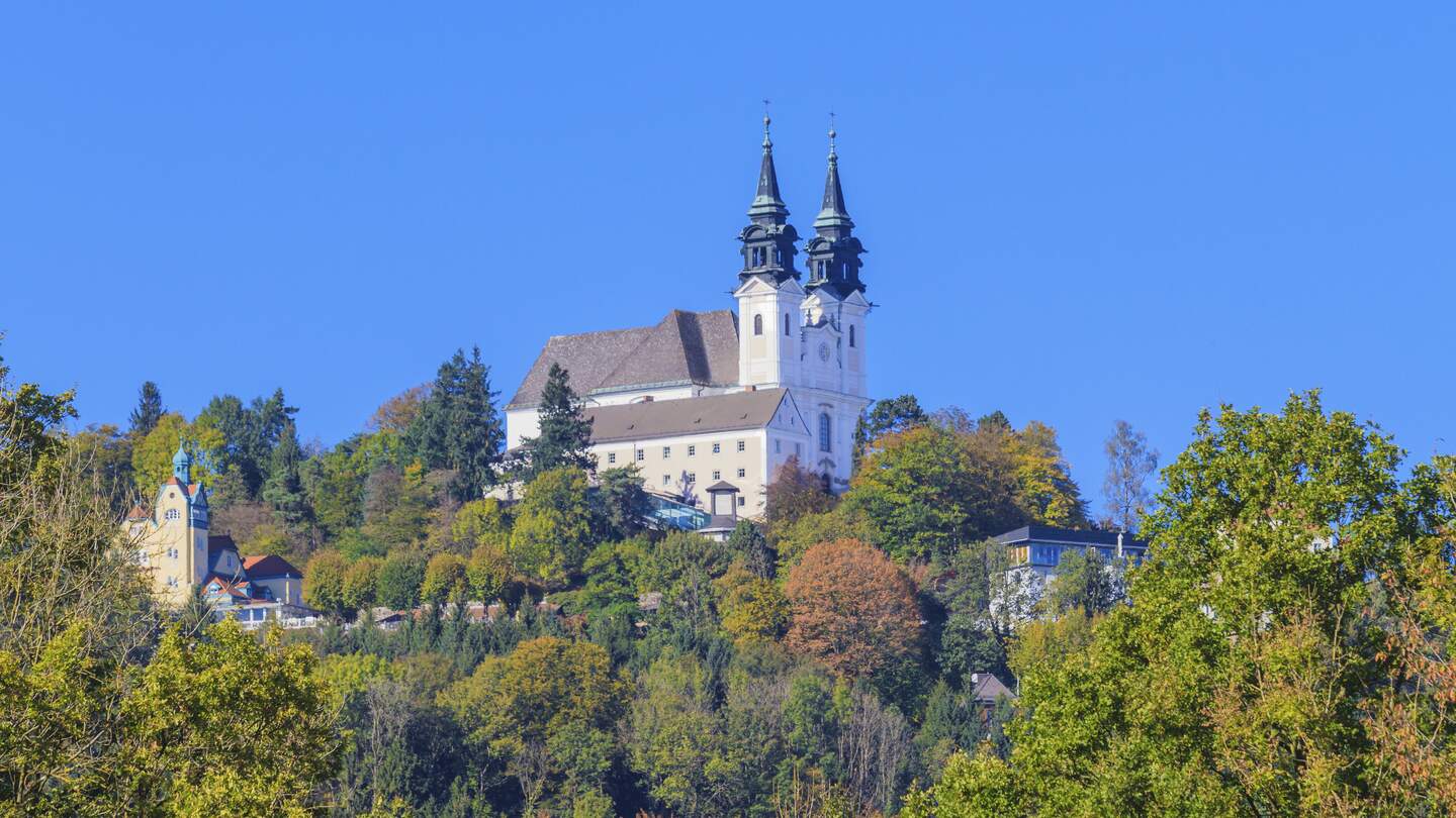 Blick auf die Basilika auf dem Poestlingberg  in Linz mit herbstlich gefaerbten Baeumen | © Gettyimages.com/Bertl123