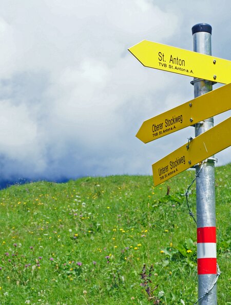 Wander-Wegweiser in St.Anton, Österreich mit gelben Schildern | © GettyImages.com/Tim Wigley