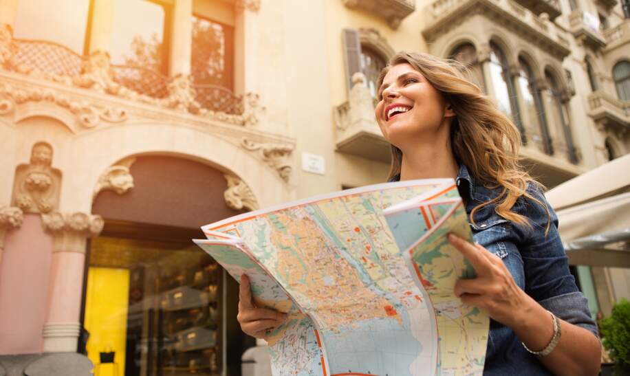Frau mittleren Alters auf Reisen, mit Karte. Europa, Barcelona. | © gettyimages.com/svetikd