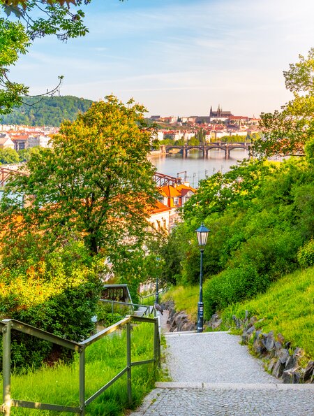 Blick auf Prag von Vysehrad mit der Karlsbrücke über die Moldau, die Prager Burg im Hintergrund und eine leuchtende Laterne am Abend im Vordergrund.  | © Gettyimages.com/PytyCzech