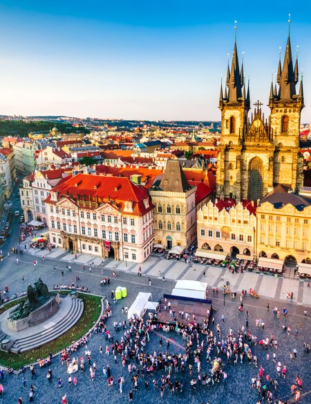 Luftaufnahme des Altstädter Rings in Prag bei Sonnenuntergang, auf dem Platz sind Menschen versammelt. | © Gettyimages.com/Eloi_Omella