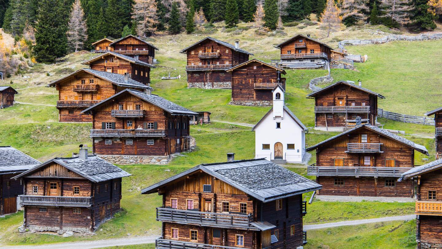 Idyllische Gruppe historischer Holzbauernhäuser auf einer Osttiroler Alm in Österreich im Herbst | © Gettyimages.com/Photofex