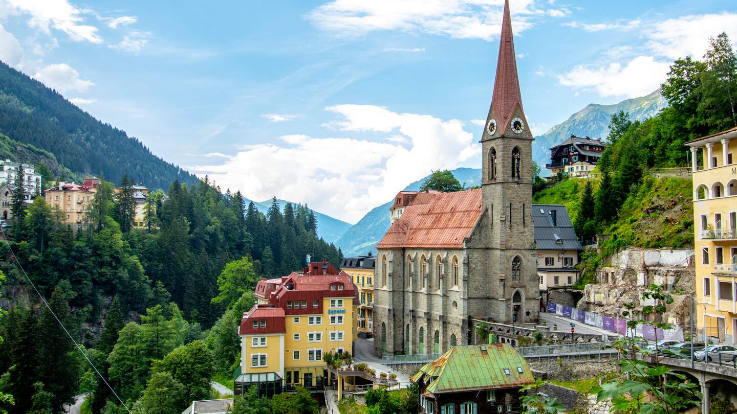 Panorama von Bad Gastein, dem Wolkenkratzerdorf im Salzburger Land an einem Sommertag mit der Kirche | © Gettyimages.com/Martin Schein