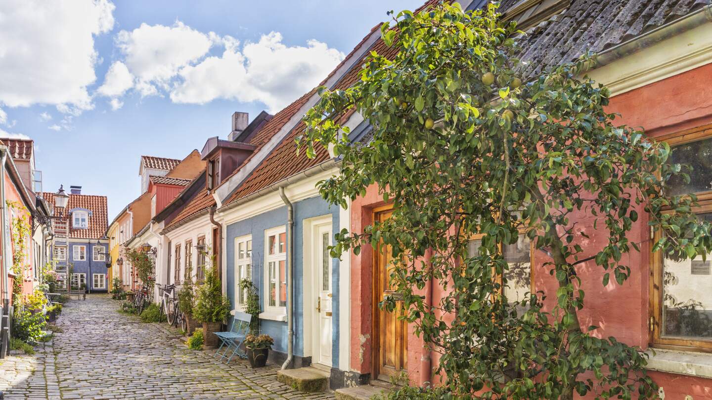 Eine idyllische Kopfsteinpflasterstraße mit bunten Häusern in der Altstadt von Aalborg | © Gettyimages.com/eyewave