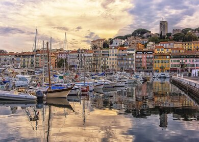 Hafen von Cannes mit bunten Häusern und Schiffen bei Sonnenuntergang | © Gettyimages.com/StockByM