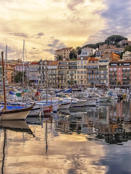 Hafen von Cannes mit bunten Häusern und Schiffen bei Sonnenuntergang | © Gettyimages.com/StockByM