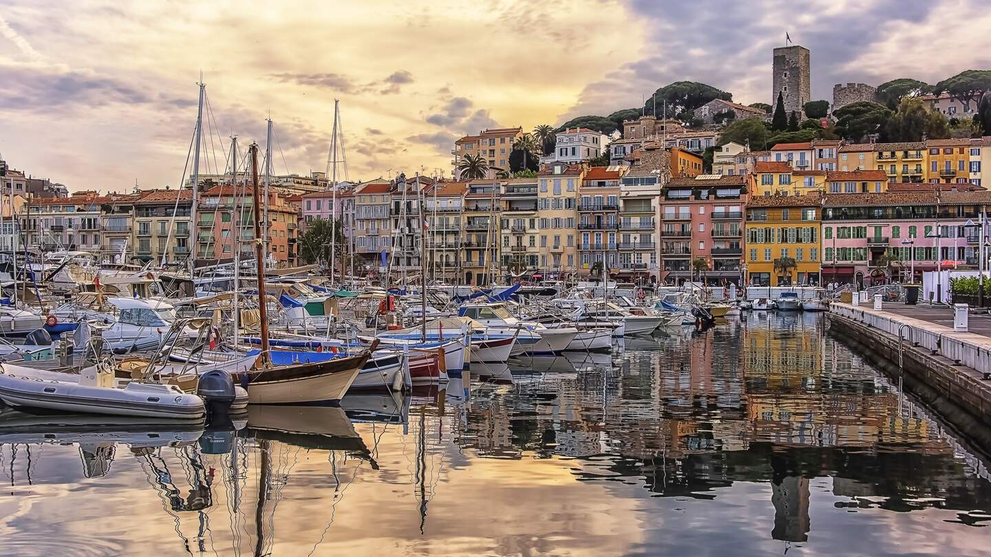 Hafen von Cannes mit bunten Häusern und Schiffen bei Sonnenuntergang | © Gettyimages.com/StockByM