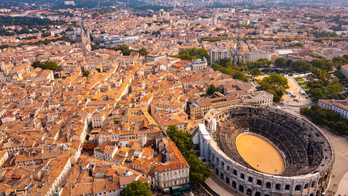 Luftaufnahme des historischen Viertels der französischen Stadt Nimes mit Blick auf das restaurierte antike römische Amphitheater am sonnigen Herbsttag | © Gettyimages.com/jackf