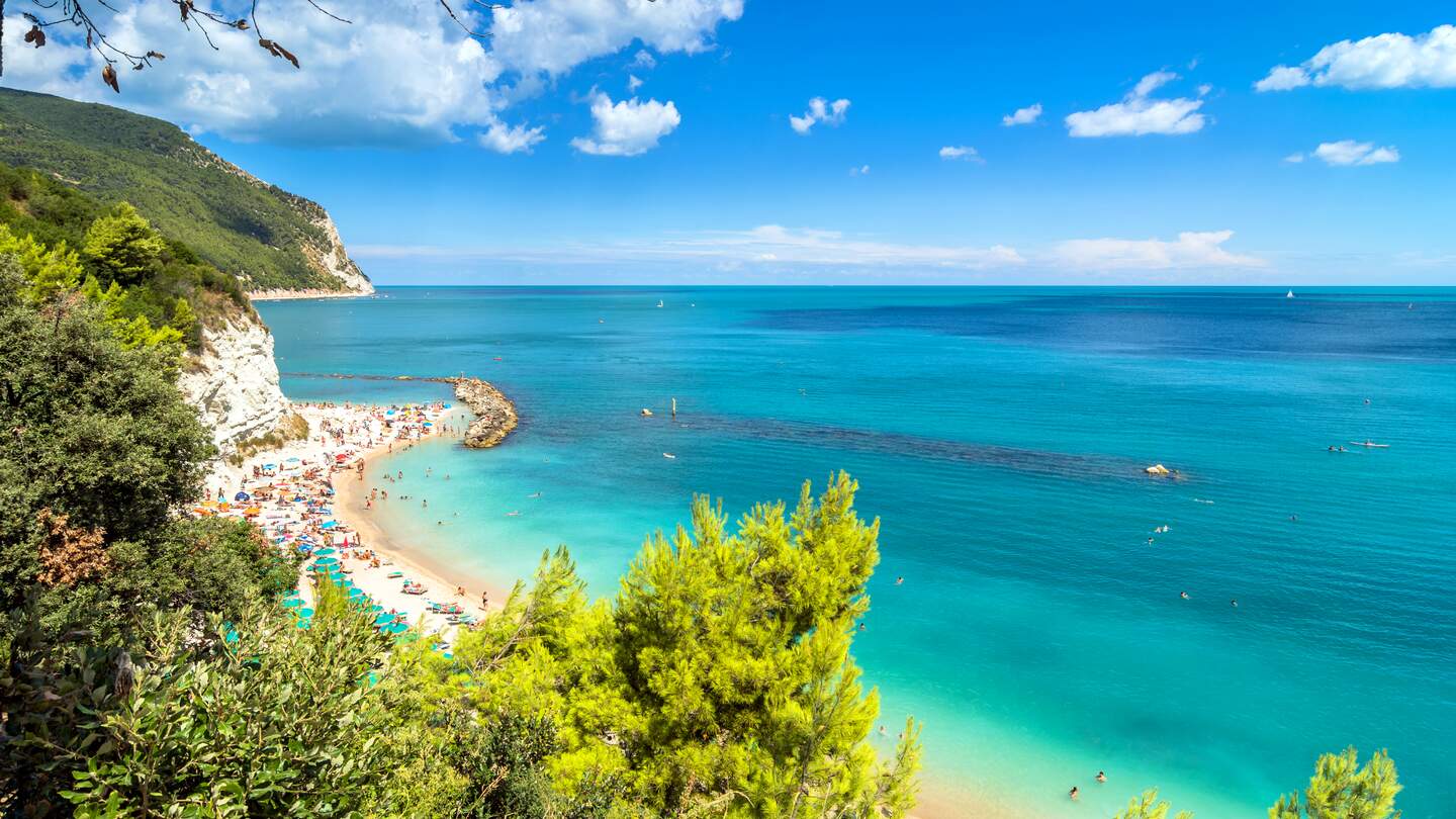 Tagesansicht des beruehmten Strandes voller Touristen in Sirolo, Italien | © Gettyimages.com/eddygaleotti