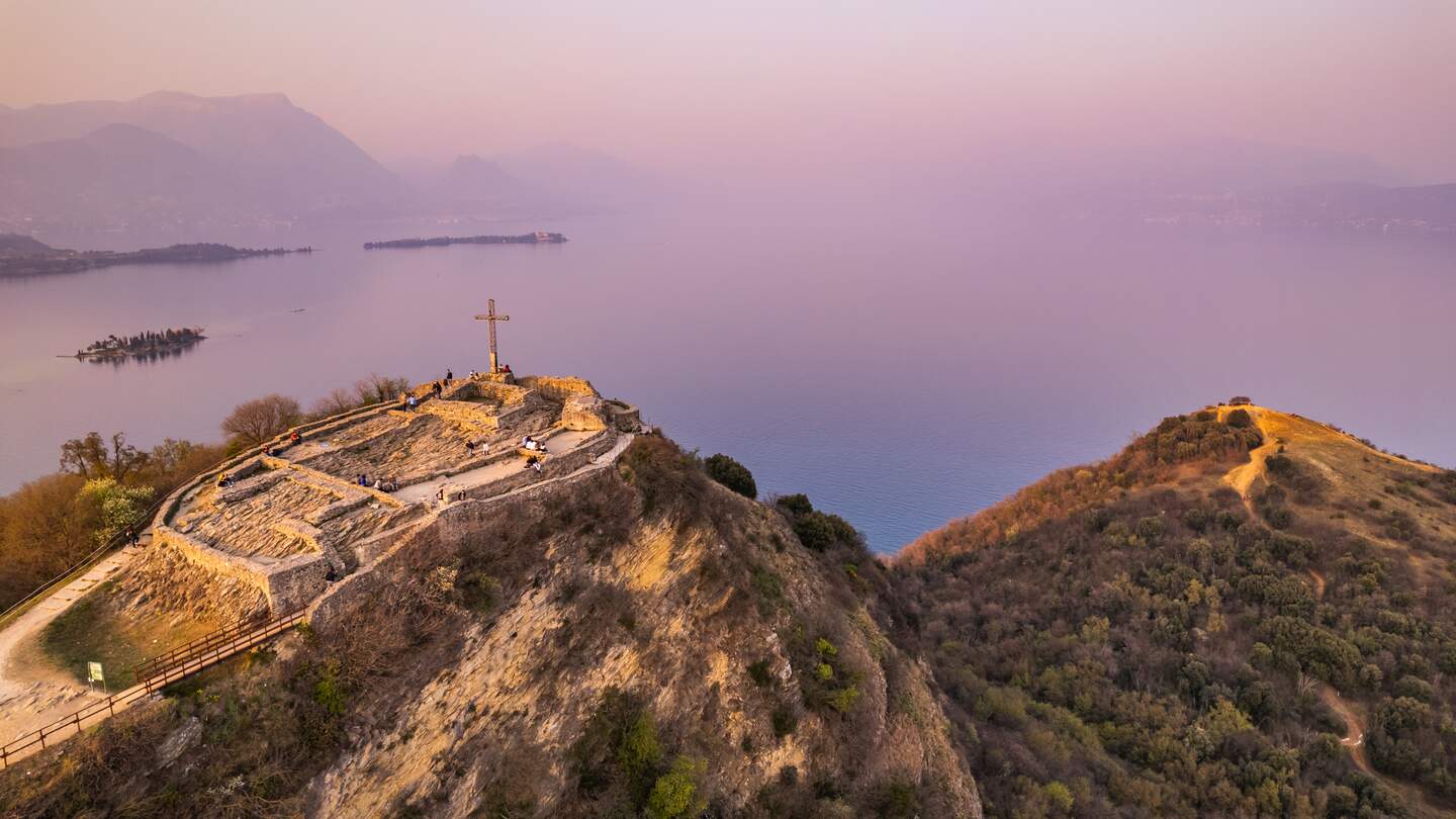 Luftaufnahme der Festung mit einem Kreuz auf einem Hügel im Hintergrund Gardasee. Panorama auf die Rocca di Manerba Draufsicht | © Gettyimages.com/fedevphoto