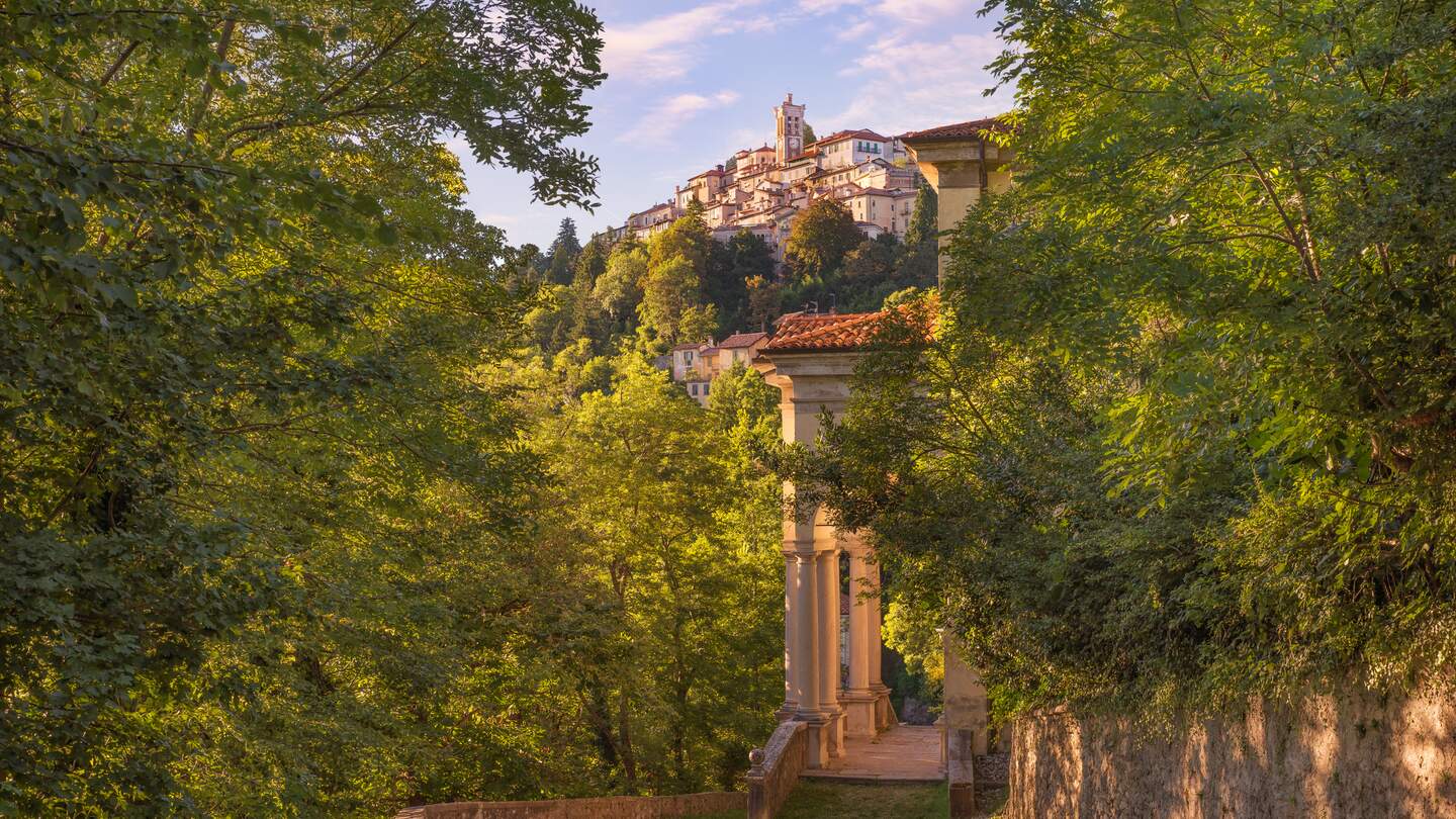 Der Sacro Monte von Varese oder Santa Maria del Monte befindet sich im Regionalpark Campo dei Fiori und ist einer der neun Sacri Monti (heilige Berge) in den italienischen Regionen Lombardei und Piemont, die 2003 in die UNESCO-Liste des Weltkulturerbes aufgenommen wurden. Es hat eine Höhe von 807 Metern über dem Meeresspiegel. Das alte Dorf mit seinen 14 Kapellen, die sich entlang eines Kiesweges von etwa 2 km schlängeln, ist wahrscheinlich die faszinierendste marianische Route der Welt. Sommerlandschaft bei Sonnenuntergang | © Gettyimages.com/alemasche72