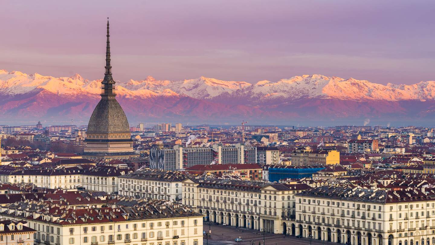 Torino (Turin, Italien): Stadtbild bei Sonnenaufgang mit Details der Mole Antonelliana, die die Stadt überragt. Scenic farbiges Licht auf den schneebedeckten Alpen im Hintergrund. | © Gettyimages.com/fabiolamanna
