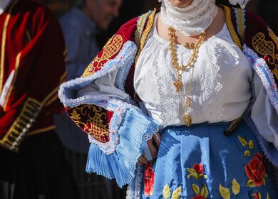 Angeschnittener Frauenkörper mit Folkskleidung aus Sardinien, Italien | © GettyImages.com/DeniseSerra