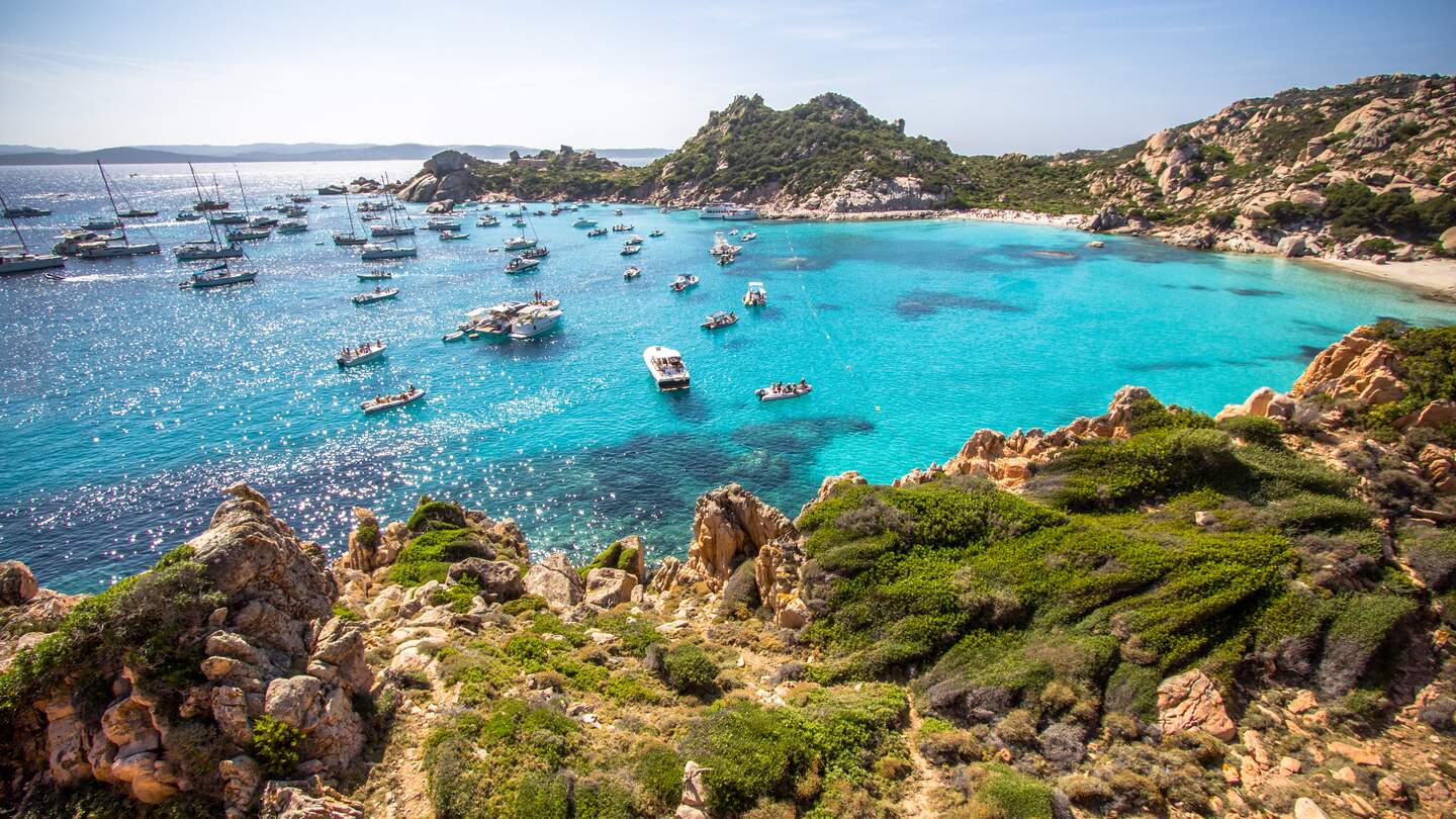 Kleine paradisische Bucht Cala Corsara auf der Insel Spargi im Maddalena Archipel, bei Sonnenschein und mit kleinen Booten | © Gettyimages.com/CAHKT