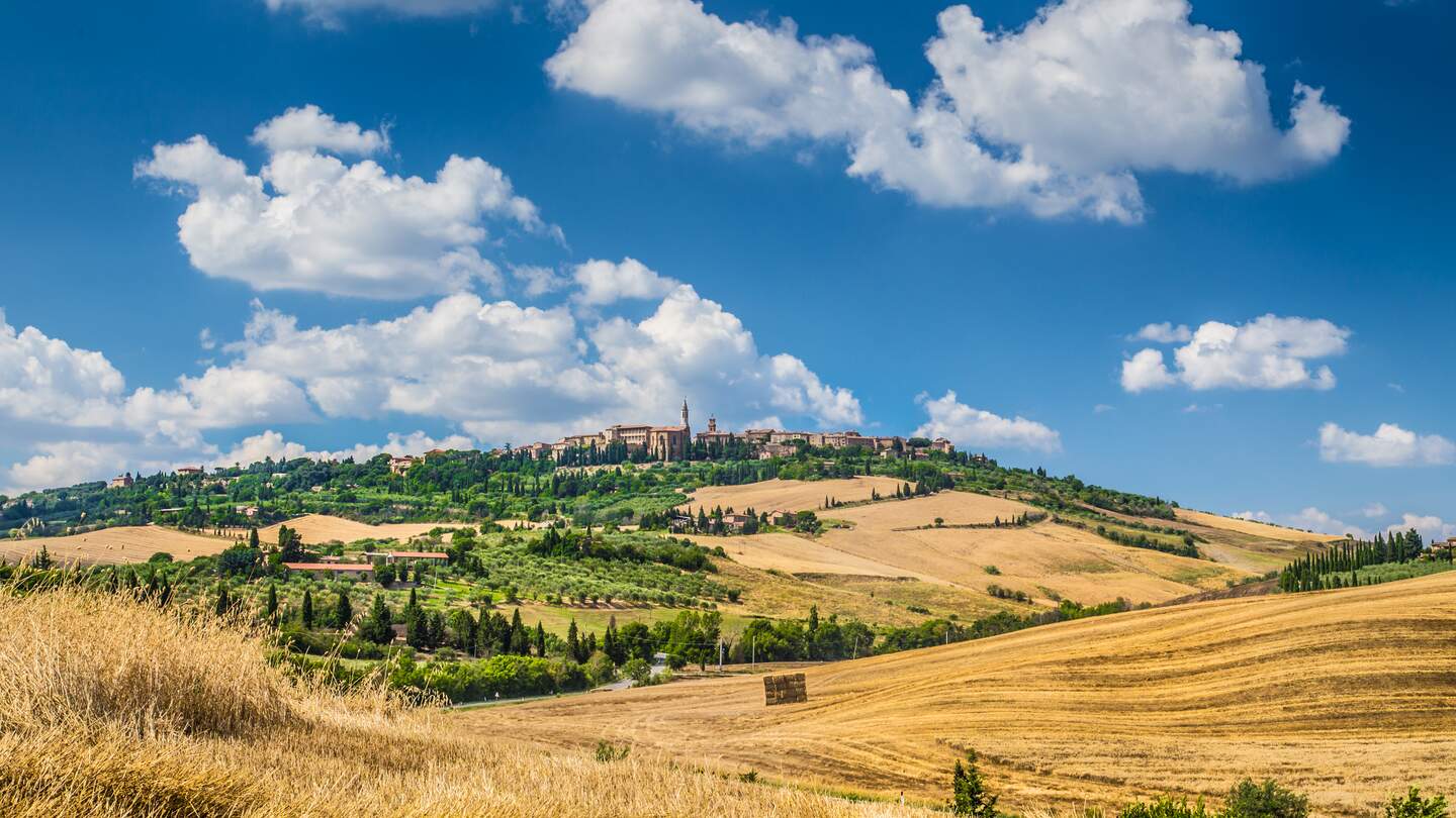 Hügelige Landschaft im Val d'Orcia mit Blick auf die Stadt Pienza | © Gettyimages.com/bluejayphoto