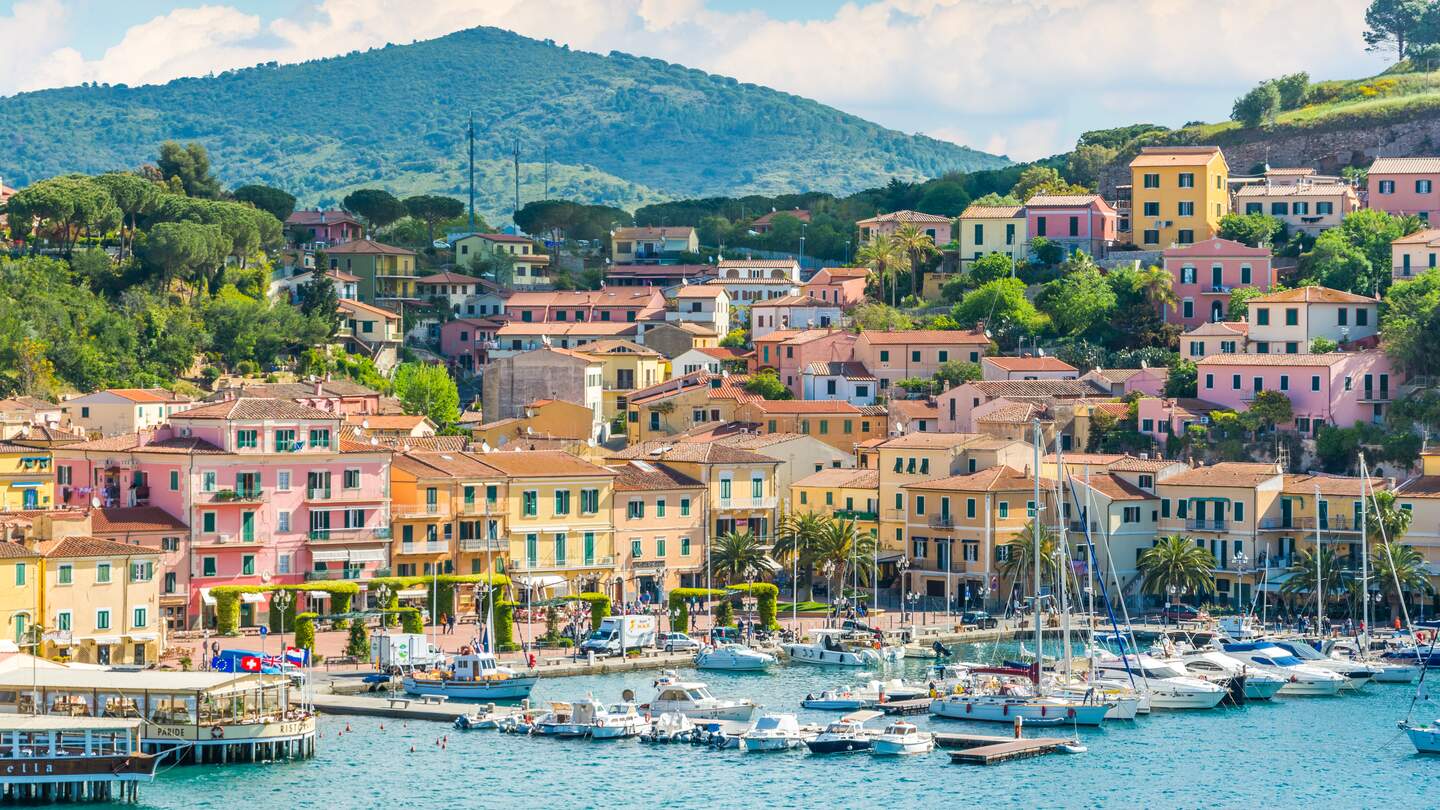 Hafen Porto Azzurro auf der Insel Elba bei Sonnenschein mit bunten Häusern | © Gettyimages.com/e55evu