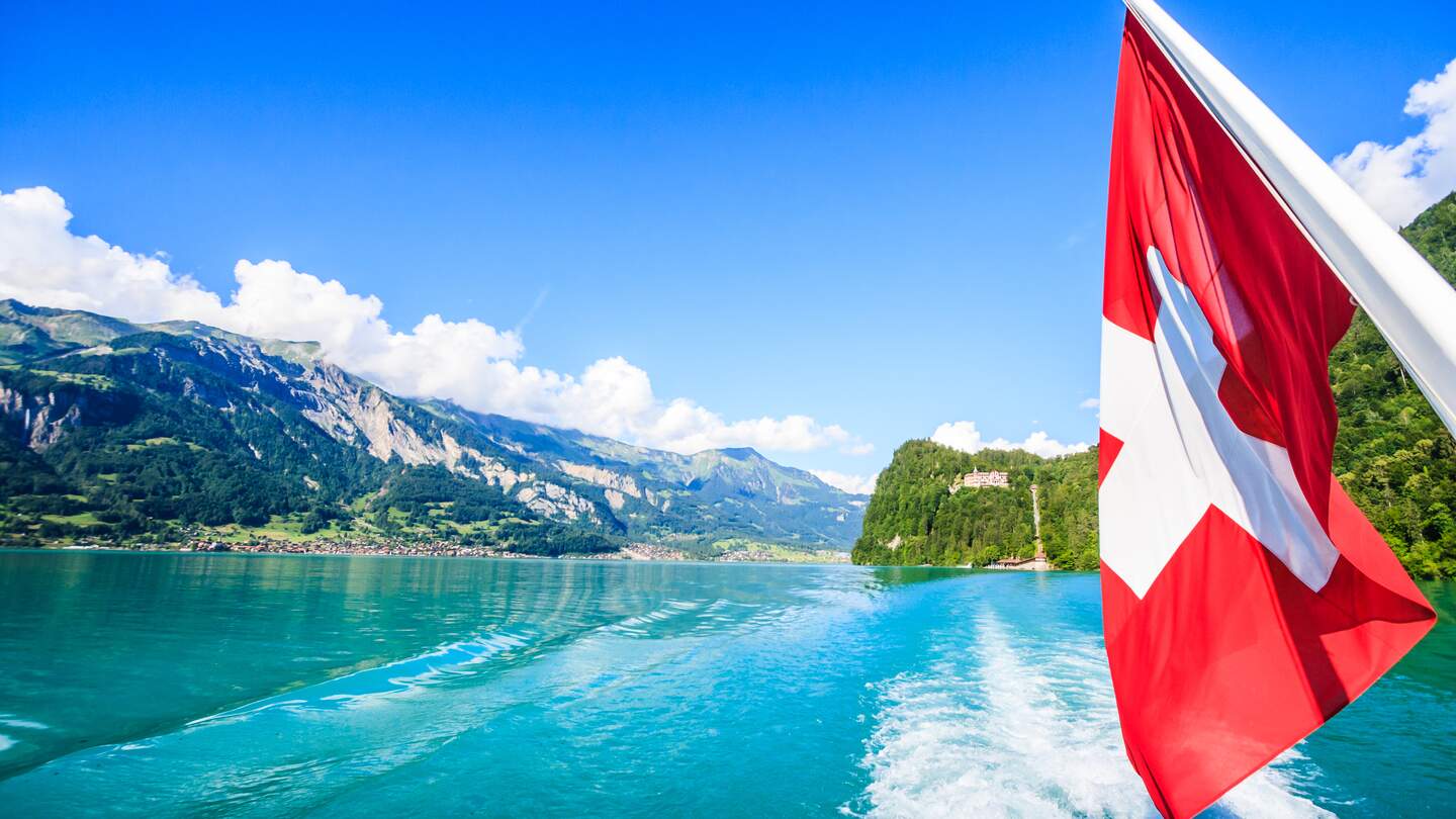 Blick auf den brienzer See von einem Boot aus, rechts sieht man wie die Schweizer flagge weht. | © Gettyimages.com/Vichai Phububphapan