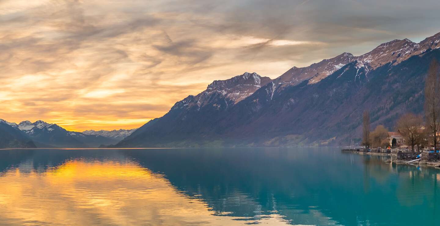 Sonnenuntergangsansicht des Dorfes und der Huegel am Brienzersee, Schweiz | © gettyimages.com/Rachapol