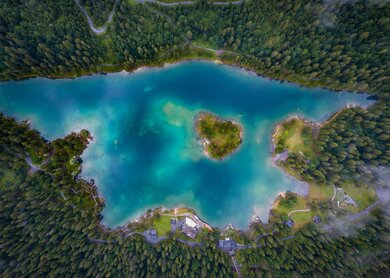 Luftaufnahme des malerischen Caumasees umgeben von dichten Waeldern in Graubuenden, Schweiz  | © Gettyimages.com/wirestock