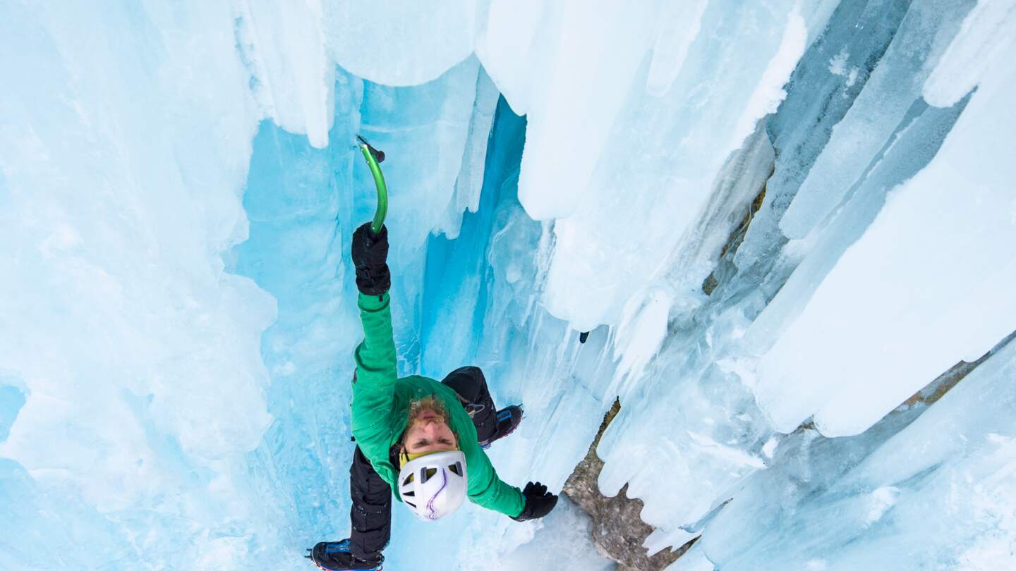 Maennlicher Kletterer klettert grosse Eiszapfen hoch | © Gettyimages.com/AlexSava