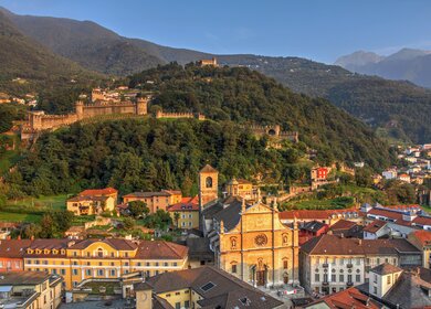 Bellinzona, mit zwei der Stadtschloesser: Montebello und Sasso Corbaro, sowie der Stiftskirche St. Peter und Stephan in der Altstadt | © gettyimages.com/BogdanLazar