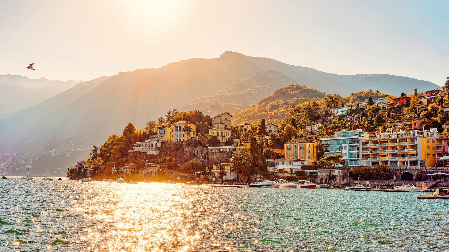 Sonnenuntergang am Abend in Ascona Luxus touristischen Resort Promenade am Lago Maggiore im Kanton Tessin in der Schweiz im Sommer. Menschen im Freien Straße reisen. Romantische Schweizer typische teure Stadt. | © Gettyimages.com/romanbabakin