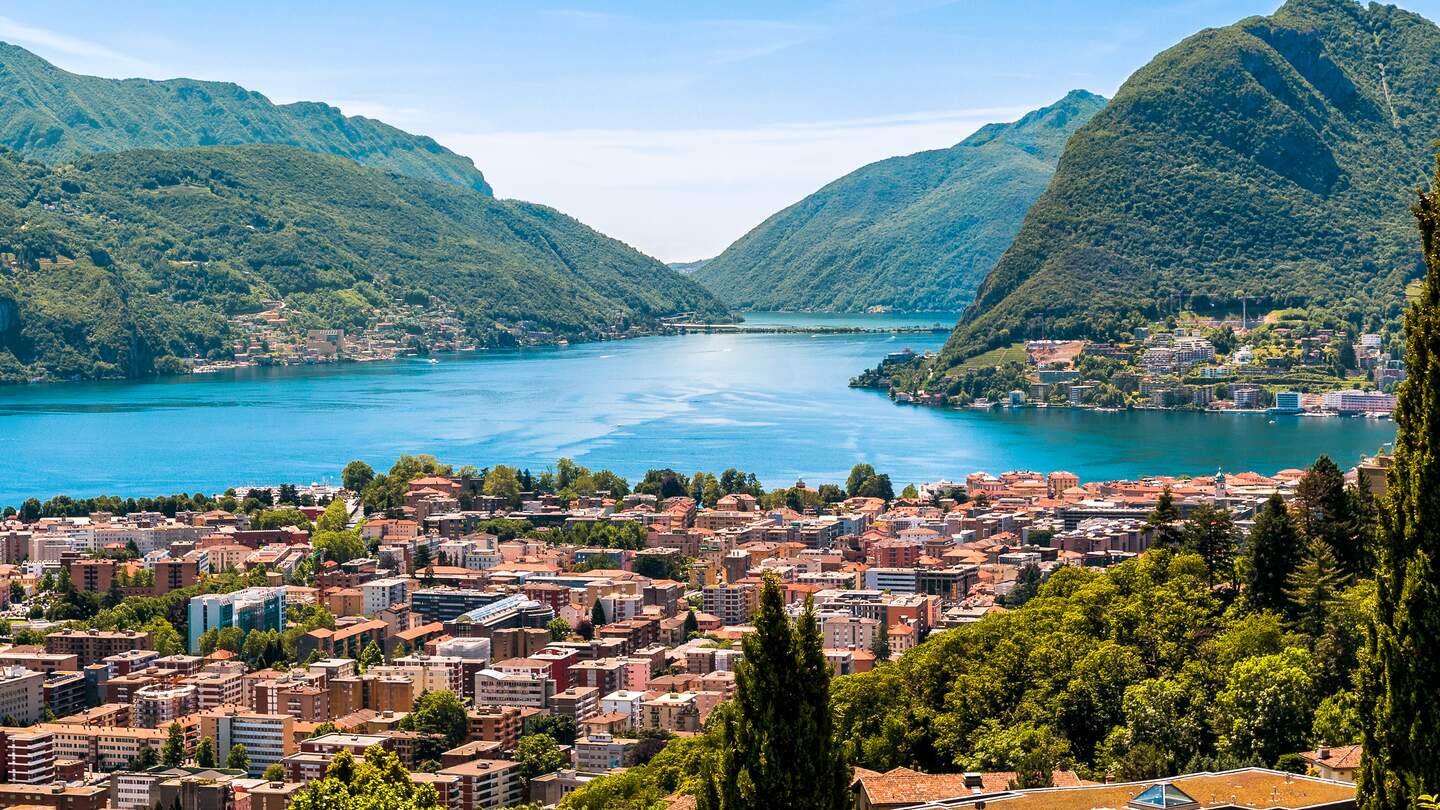 Landschaft des Luganer Sees, der Berge und der Stadt unten, Tessin Schweiz | © gettyimages.com/EleSi