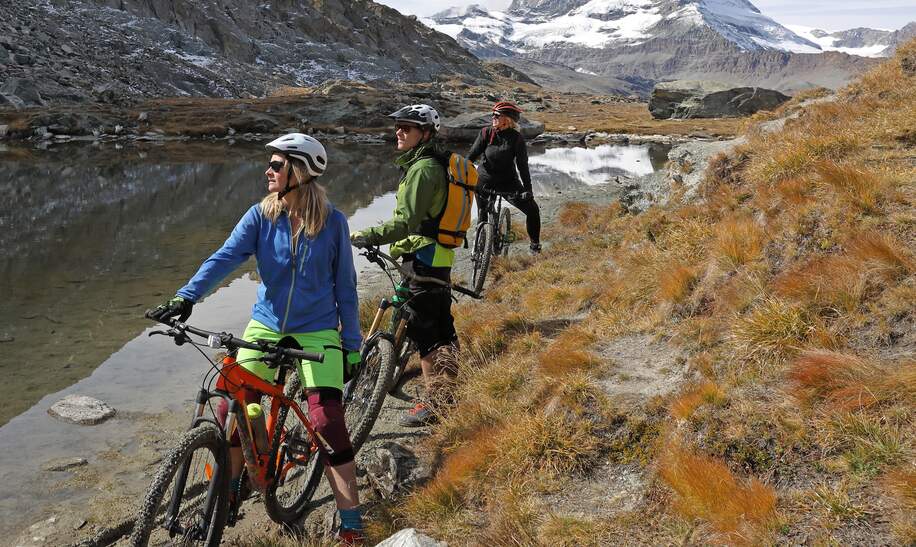 Mountainbikerfamilie bewundert den Blick vom Riffelsee see unterhalb des Matterhorns | © gettyimages.com/AscentXmedia
